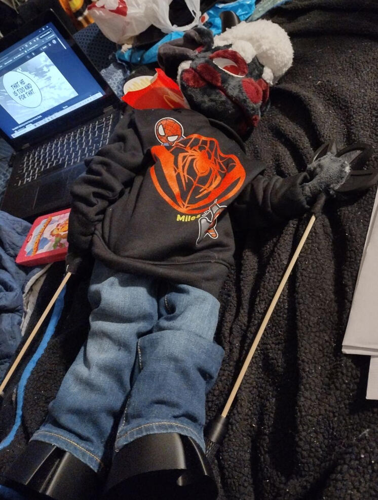 Princeton Kingsley, vilias blacknose sheep puppet Blackfured white wooled and red cheeks patched Sheep puppet wearing blue jeans and a spiderman hoodie